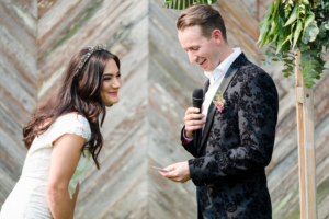 1 bride laughing as groom reads vowels during wedding in Melbourne