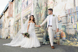 Bride and groom holding hands in front of East West Design in Fremantle