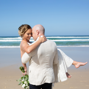 Groom holding bride on beach after New South Wales wedding