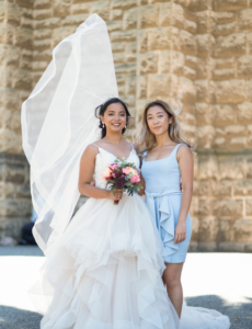Bride and friend posing outside church for Perth wedding