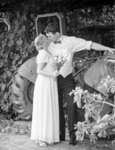 Couple kissing in front of Tractor at country wedding