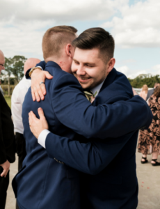 groom hugging groomsman after wedding ceremony in Camden