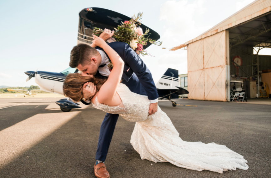photo of bride and groom kissing at Camden Airport after wedding