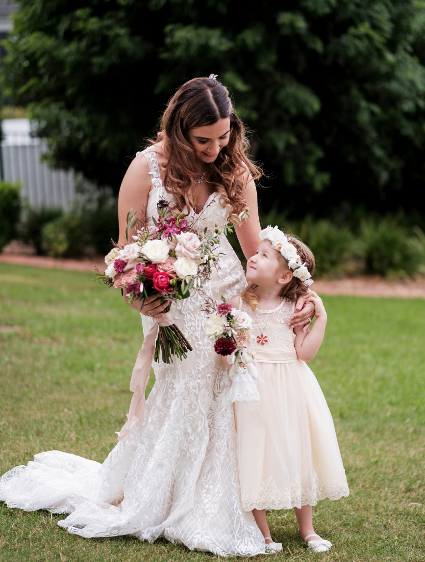 Bride and flower girl posing for photographer before wedding in NSW