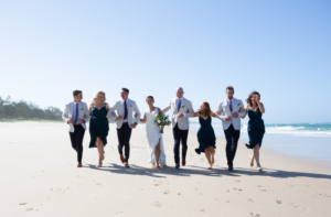 Wedding party running on beach in New South Wales