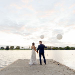 Bride and groom holding balloons at sunset after Melbourne wedding