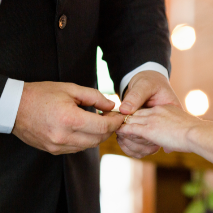 Groom giving bride ring during wedding ceremony