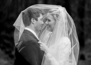 Black and white photo of bride and groom under veil in Canberra wedding