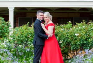 1 bride in red dress hugging groom