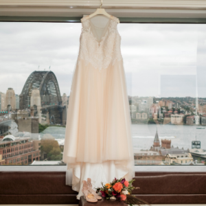 wedding dress handing on window overlooking Sydney