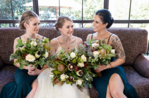 1 smiling bride and bridesmaids holding native Australian bouquets