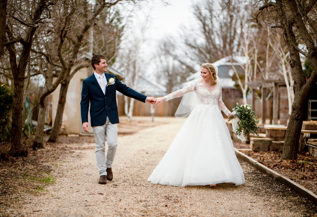1 Bride and groom holding hands under winter trees