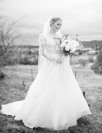 Black and white bride looking at bouquet