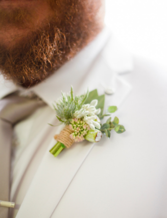 close up photo of grooms white suit jacket