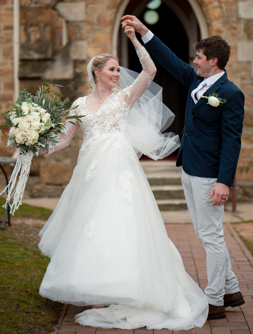 newlyweds dancing in front of church - winter wedding