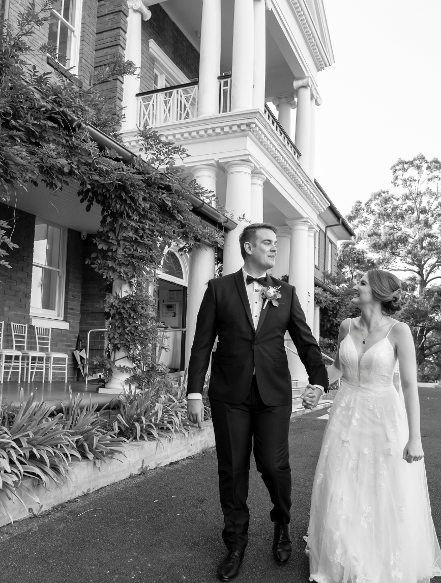 Bride and groom walking in front of Cropley House