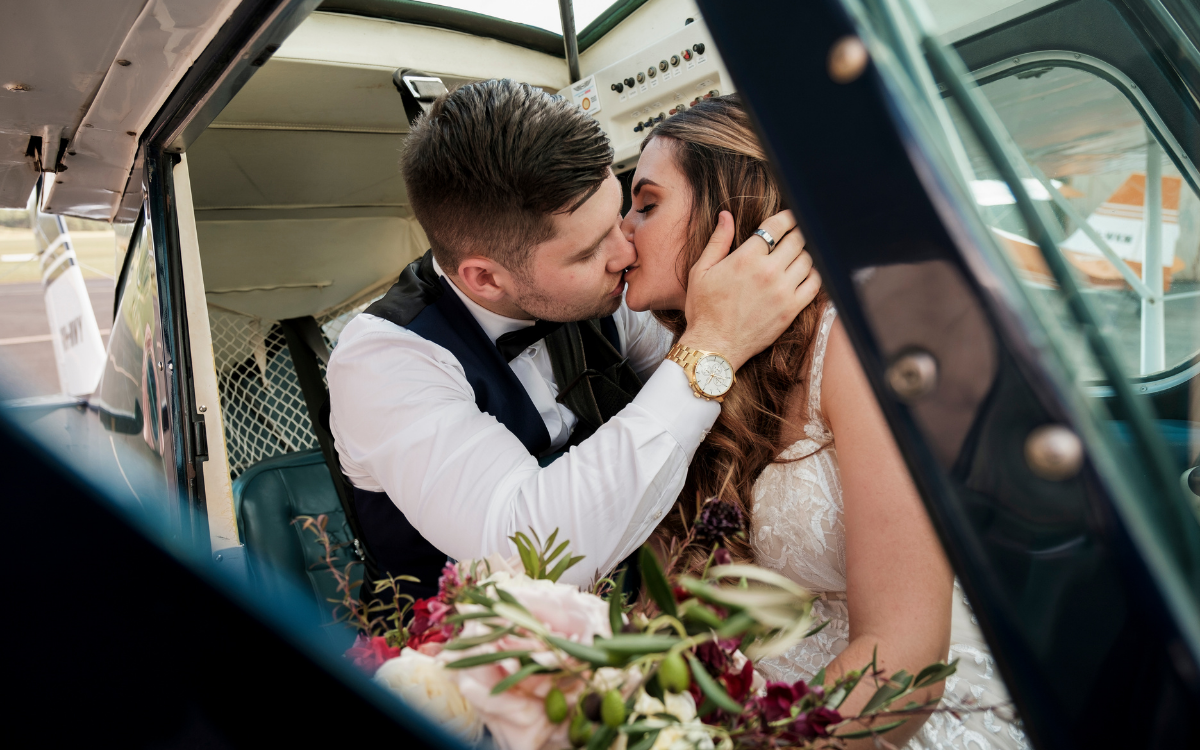 1 bride and groom kissing in plane