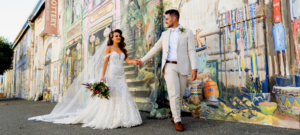 bride and groom holding hands in front of East West Design in Fremantle