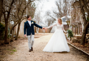 Bride and groom holding hands under winter trees