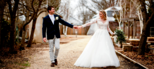 1 Bride and groom walking through leafless trees at winter wedding