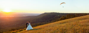 Bride and groom on mountainside at sunset