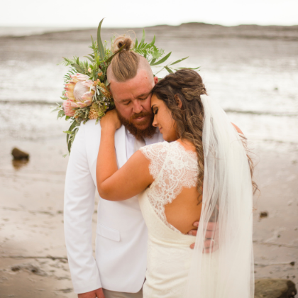 1 bride and groom hugging on beach in New South Wales