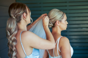 1 photo of bridesmaid helping bride with veil