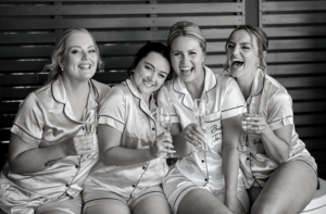 bride laughing with bridesmaids before wedding