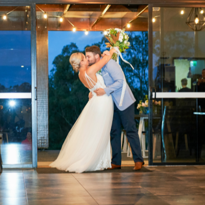 bride and groom kissing as they enter their reception at oceanview estates