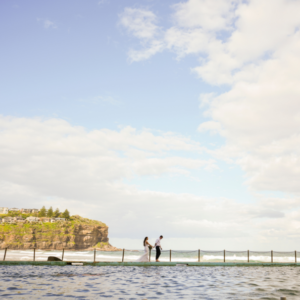 bride and groom walking along jetty at Bigola Surf Livesaving club