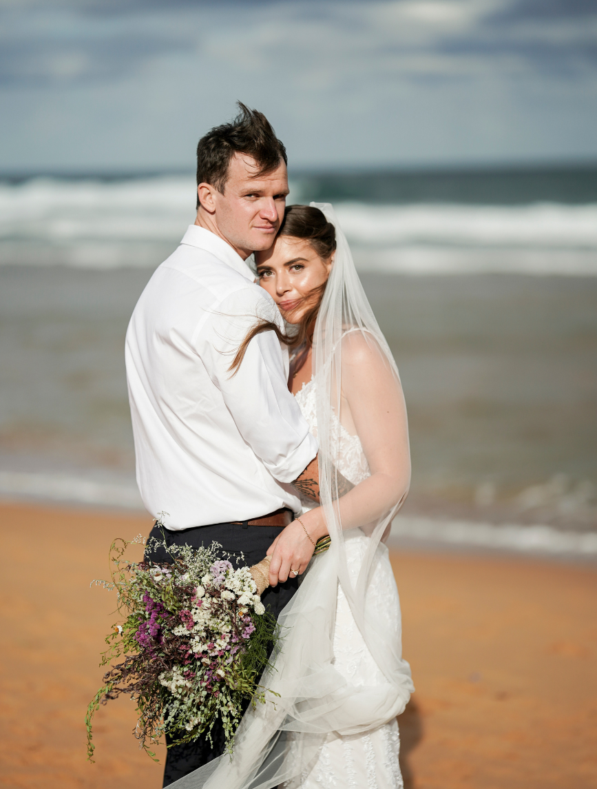 bride and groom hugging on Bigola beach after wedding