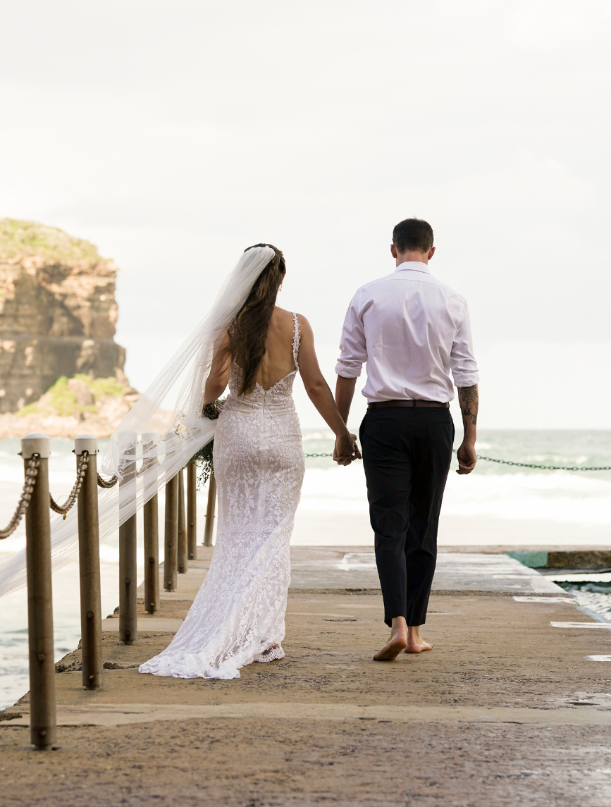 married couple walking along jetty at Bigola Beach