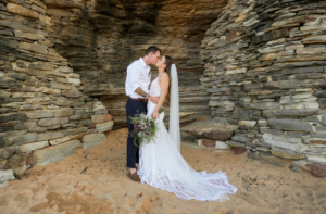 bride and groom kissing on Bigola beach after wedding