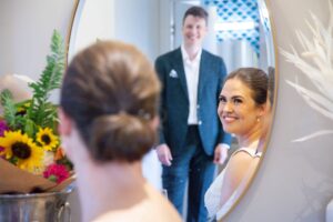 bride looking at groom in mirror in Canberra