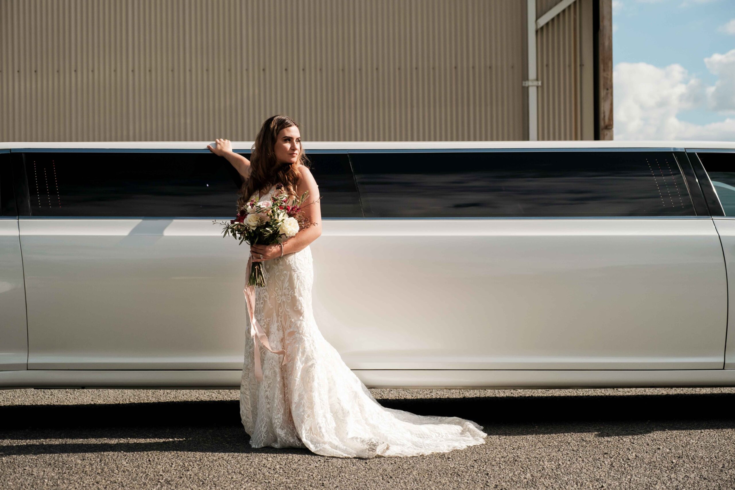 bride standing in front of limousine