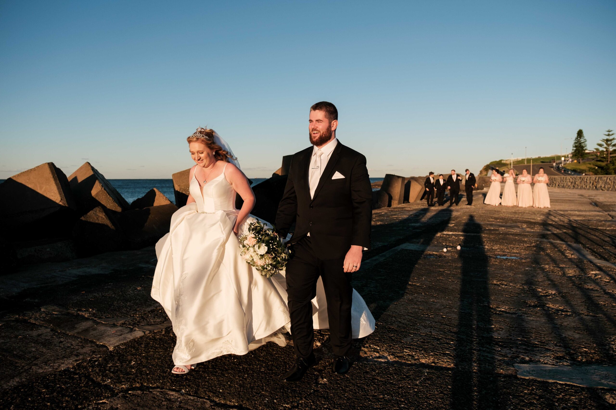 couple walking near wollongong breakwater lighthouse after wedding