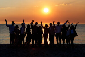 sunset photo of bridal party on beach after wedding