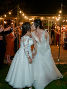 bride and bride kissing after reception at Log Cabin Ranch