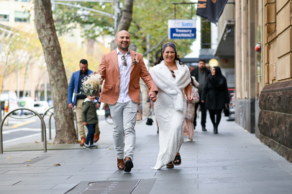 photo of bride and groom walking through Melbourne CBD