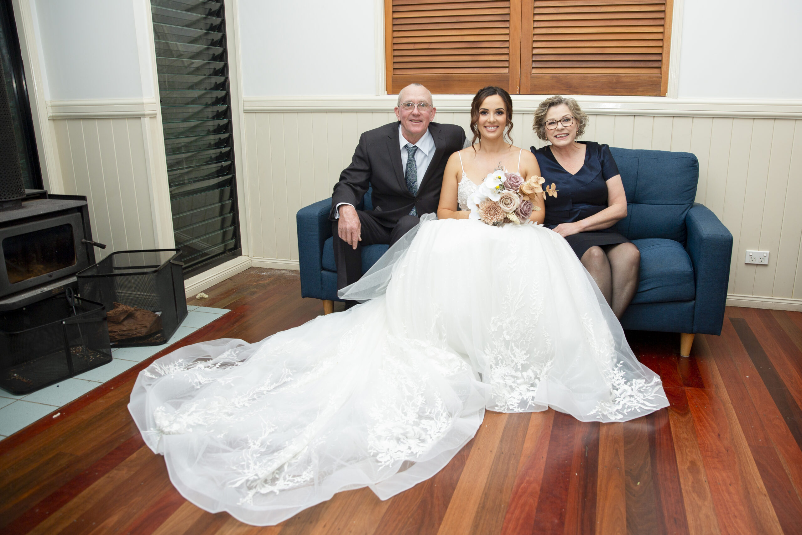 Bride sitting on couch with parents.