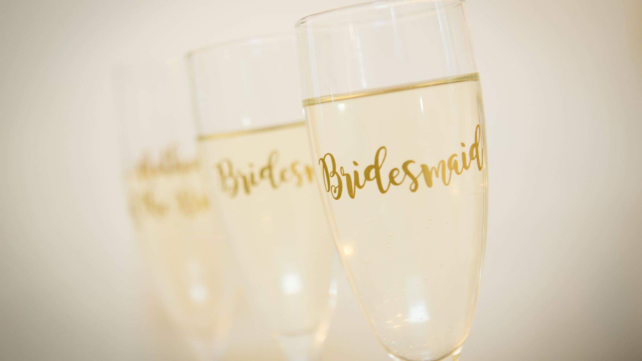 Wine Glasses with 'bridesmaid' written on them in gold. 