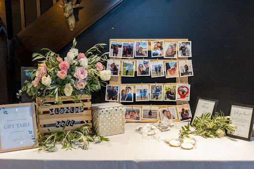 Wishing well and photo display on wedding gift table.
